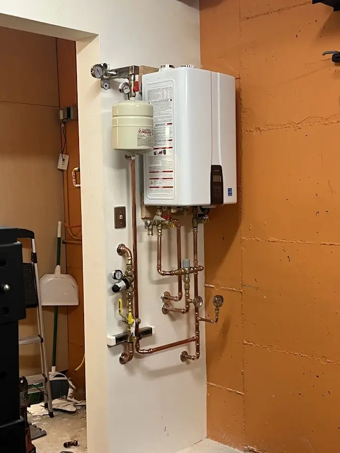 Plumbing technician inspecting water heater connections in Satsuma